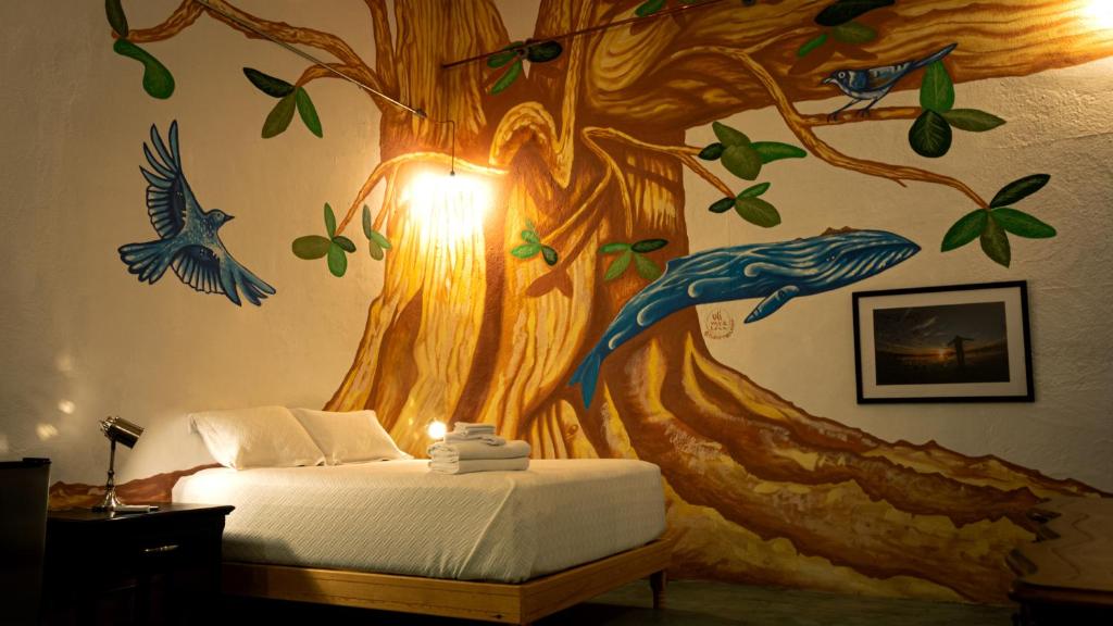 a bedroom with a tree mural on the wall at Casa Bahia in La Paz