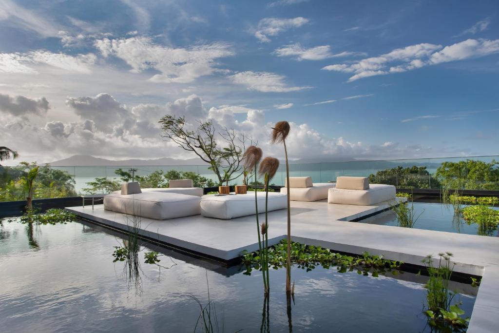 フロリアノポリスにあるFuso Concept Hotelの白いソファ付きのリビングルームが備わり、水辺の景色を望めます。