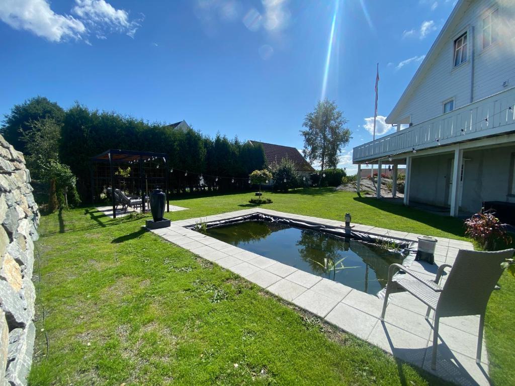 a pool in a yard next to a building at Family house close to the beach in Mosterhamn