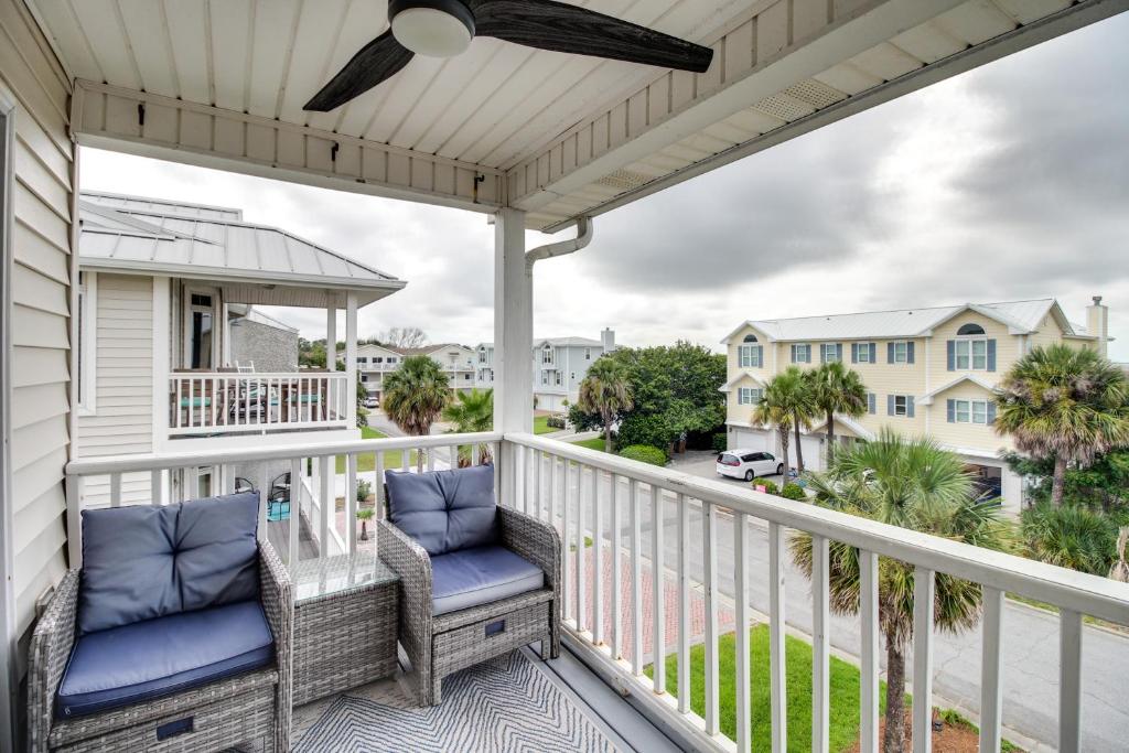a balcony with two chairs and a view of the street at Elegant Tybee Island Townhome, Steps to Beach in Tybee Island
