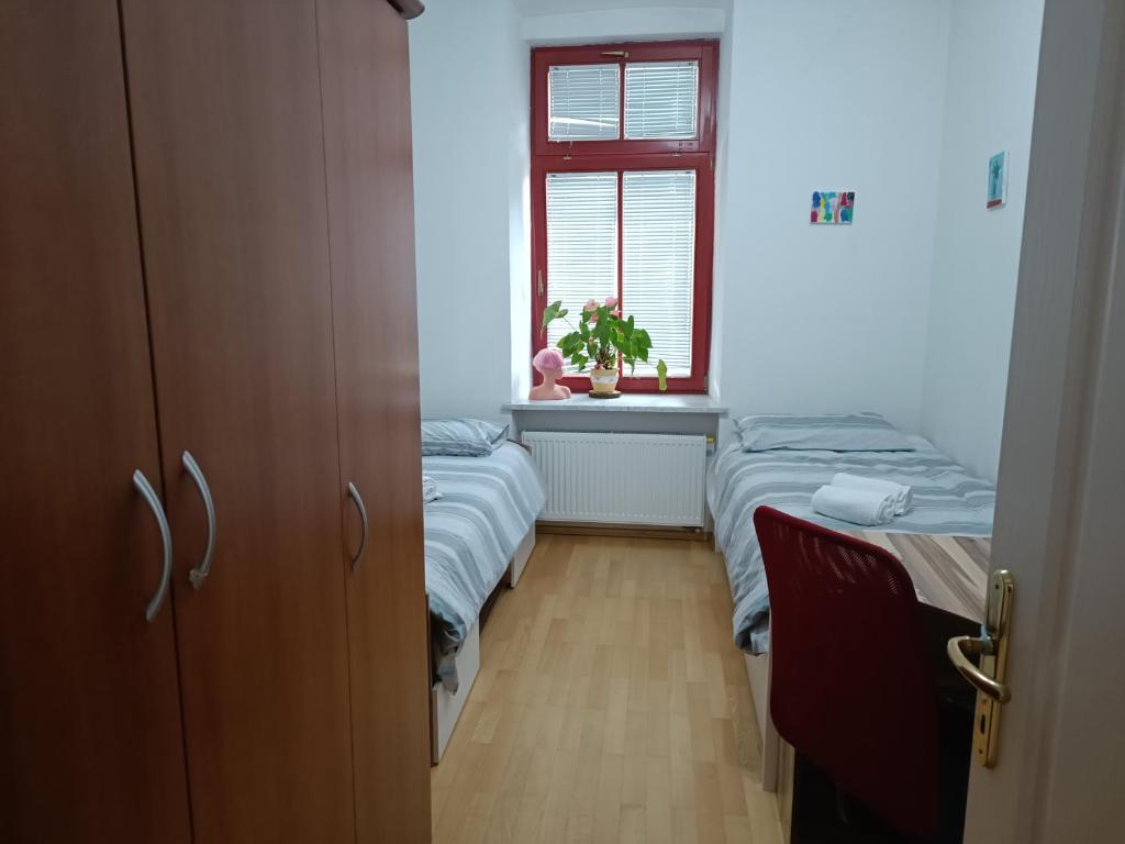 Cette petite chambre comprend 2 lits et une fenêtre. dans l'établissement Apartma MOST, à Kanal