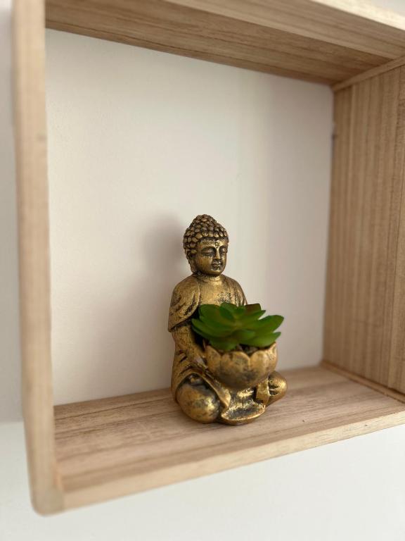 a statue sitting on a shelf with a plant at Cozy home&amp;garden (Paris&#47;Disney) in Noisy-le-Sec