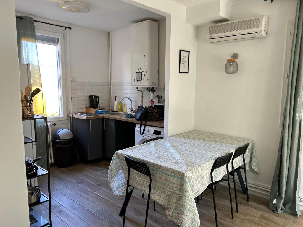 a kitchen with a table and a table and chairs at Cozy home&amp;garden (Paris&#47;Disney) in Noisy-le-Sec