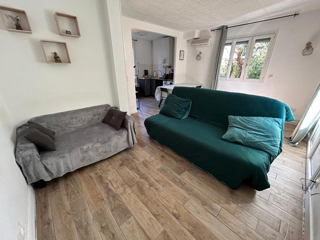 a living room with a green couch and a chair at Cozy home&amp;garden (Paris&#47;Disney) in Noisy-le-Sec