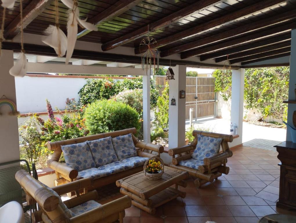 eine Terrasse mit einem Sofa und Stühlen unter einer Pergola in der Unterkunft Villa San Leo in San Leone
