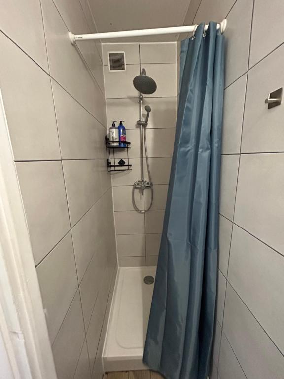 a shower with a blue shower curtain in a bathroom at Cozy home&amp;garden (Paris&#47;Disney) in Noisy-le-Sec