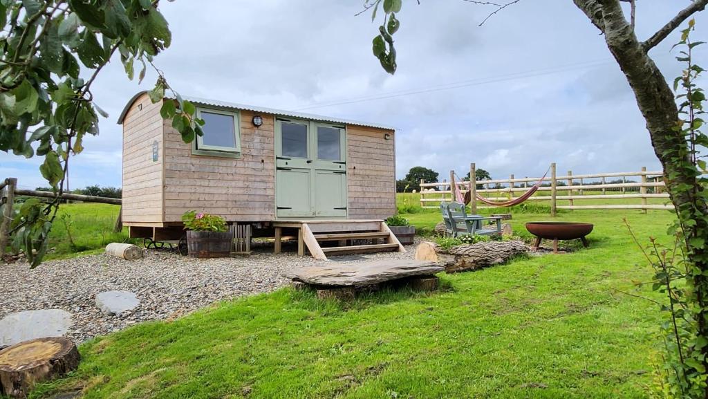 a tiny house with a picnic table and a bench at Shepherds Delight in Werrington