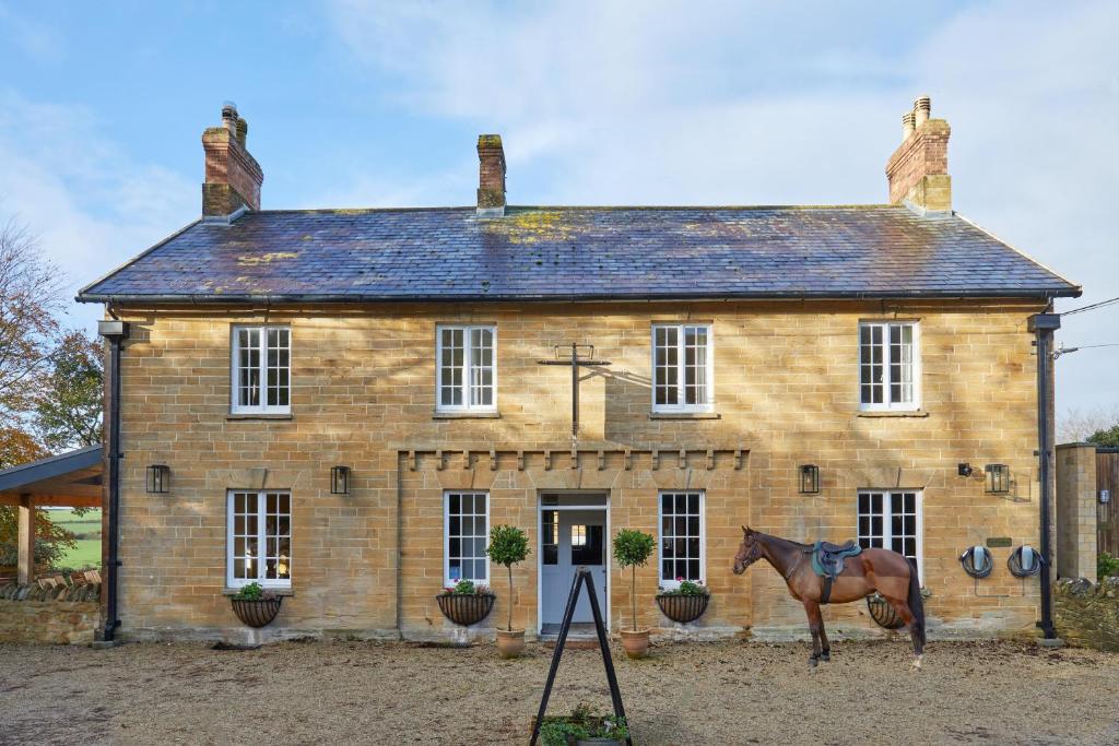 a horse standing in front of a house at The Queens Arms in Sherborne