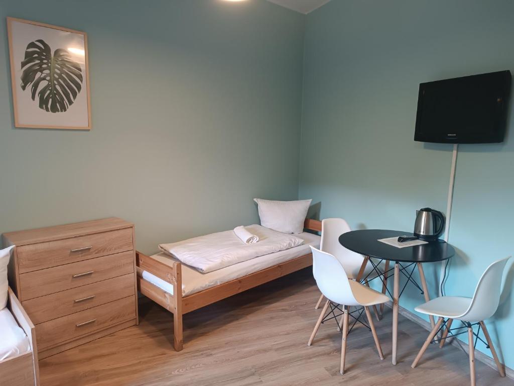 a small room with a bed and a table and chairs at U Józefa in Tychy