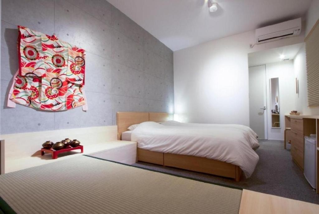 Sweet Stay Kyoto - Vacation STAY 13383v في كيوتو: غرفة نوم بسرير كبير ولوحة حمراء على الحائط