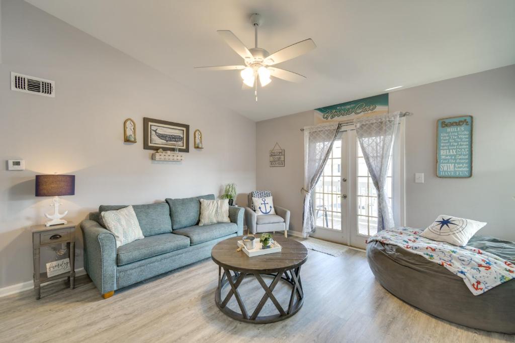 a living room with a couch and a table at Gulf Shores Condo with Pool Access, 5 Mi to Beach! in Gulf Shores