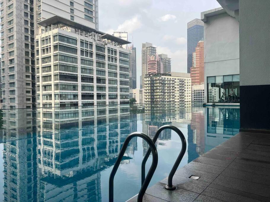 uma varanda com vista para uma cidade com edifícios em One Bukit Ceylon Hosted by TCL Home 9062 em Kuala Lumpur