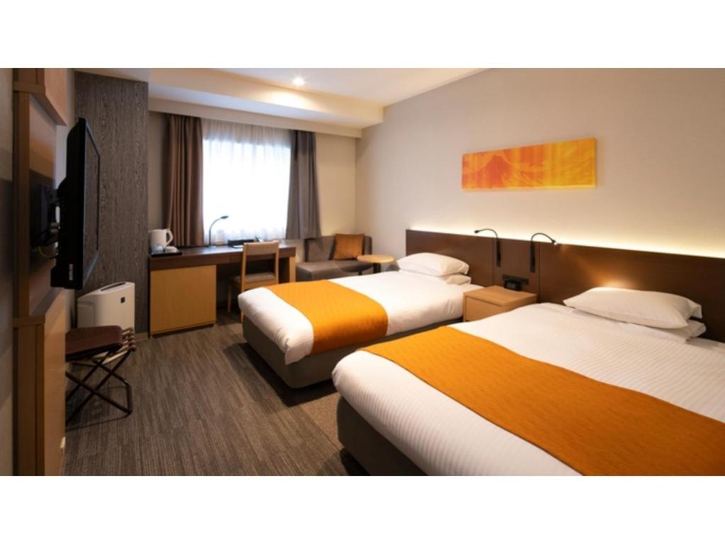 Habitación de hotel con 2 camas y escritorio en La'gent Stay Sapporo Odori - Vacation STAY 63867v, en Sapporo