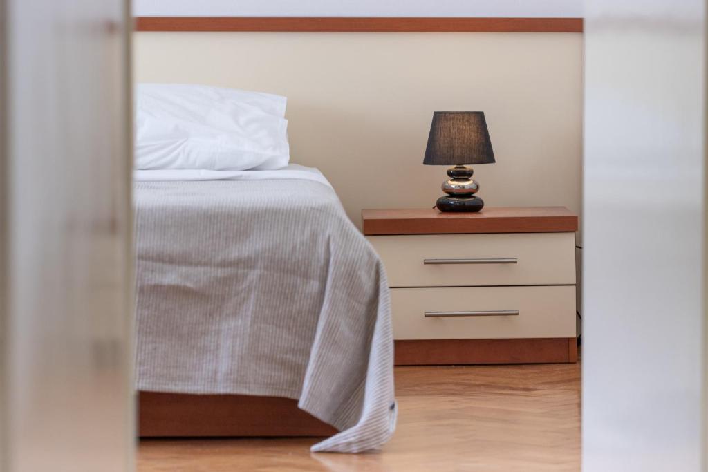 1 dormitorio con cama y mesita de noche con lámpara en Apartment Sunce 1-bedroom apartment in Split, en Split