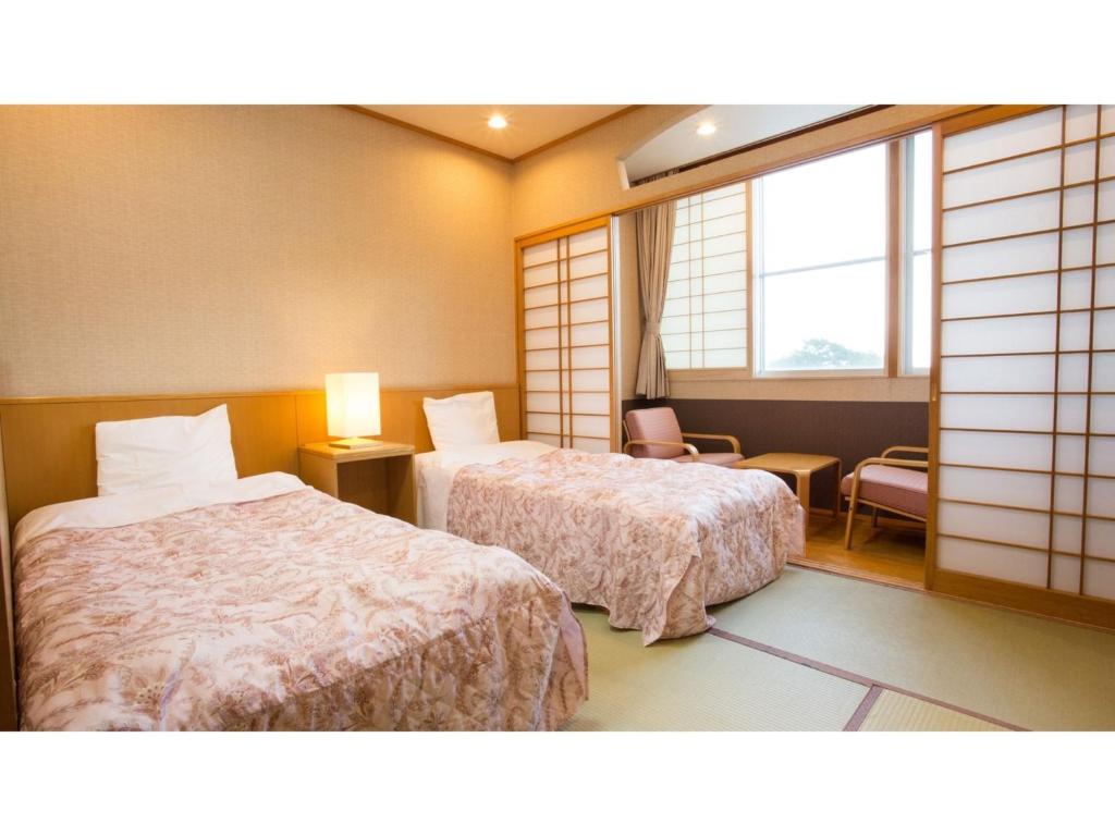 a hotel room with two beds and a window at Hotel Keipu - Vacation STAY 11139v in Hakodate