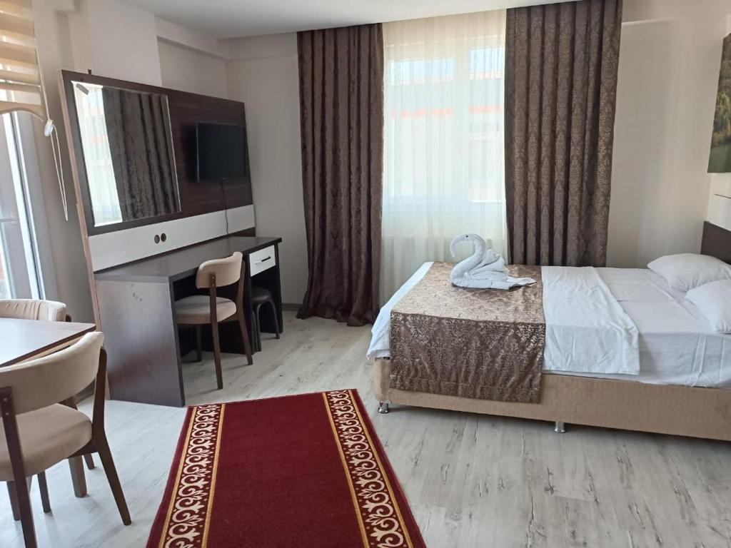 a hotel room with a bed and a desk and a television at TERAS REZIDANs in Bergama