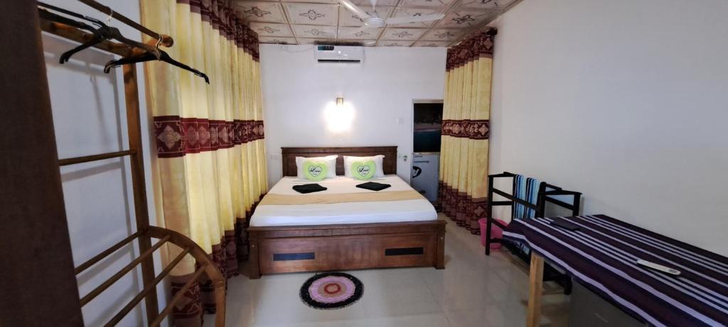 a small bedroom with a bed and a bench at Kavidi Villa Home Stay in Tangalle