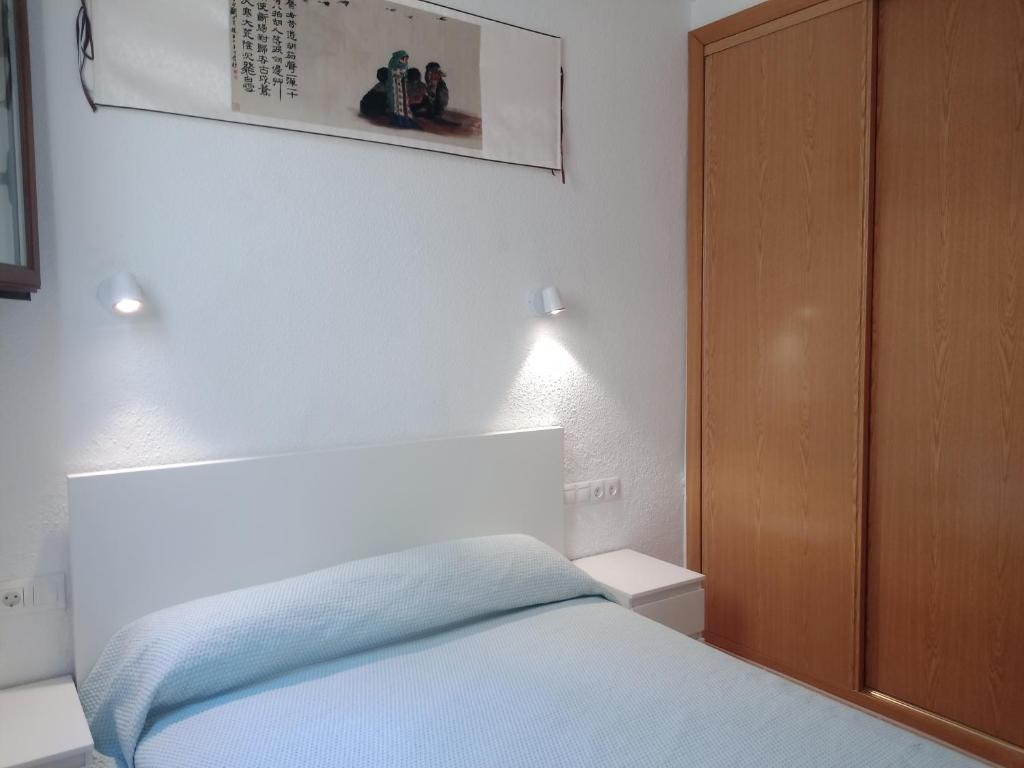 a bedroom with a bed and a wooden cabinet at 2 dormitorios y el salón tienen aire, Madrid Centro Gran Vía - Plaza de España in Madrid
