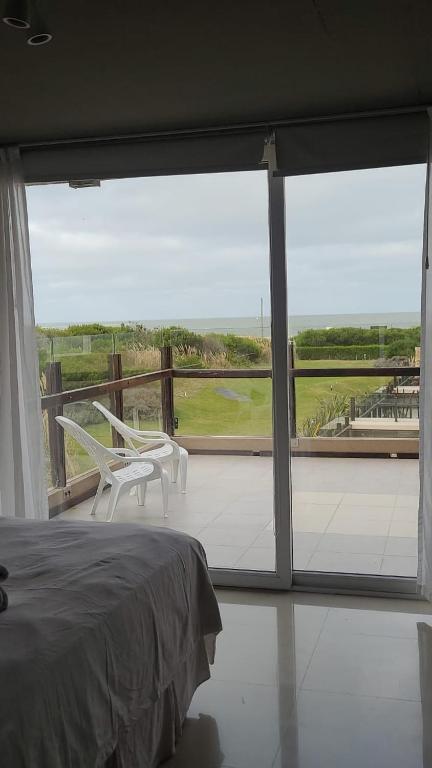 a bedroom with a bed and a large glass window at LINDABAYPLAYA STUDIO in Mar de las Pampas