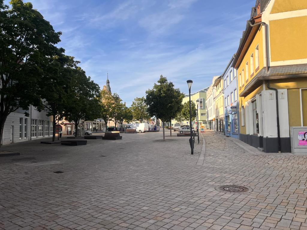 pusta ulica w mieście z budynkami i drzewami w obiekcie Mitten im Herzen w mieście Schönebeck