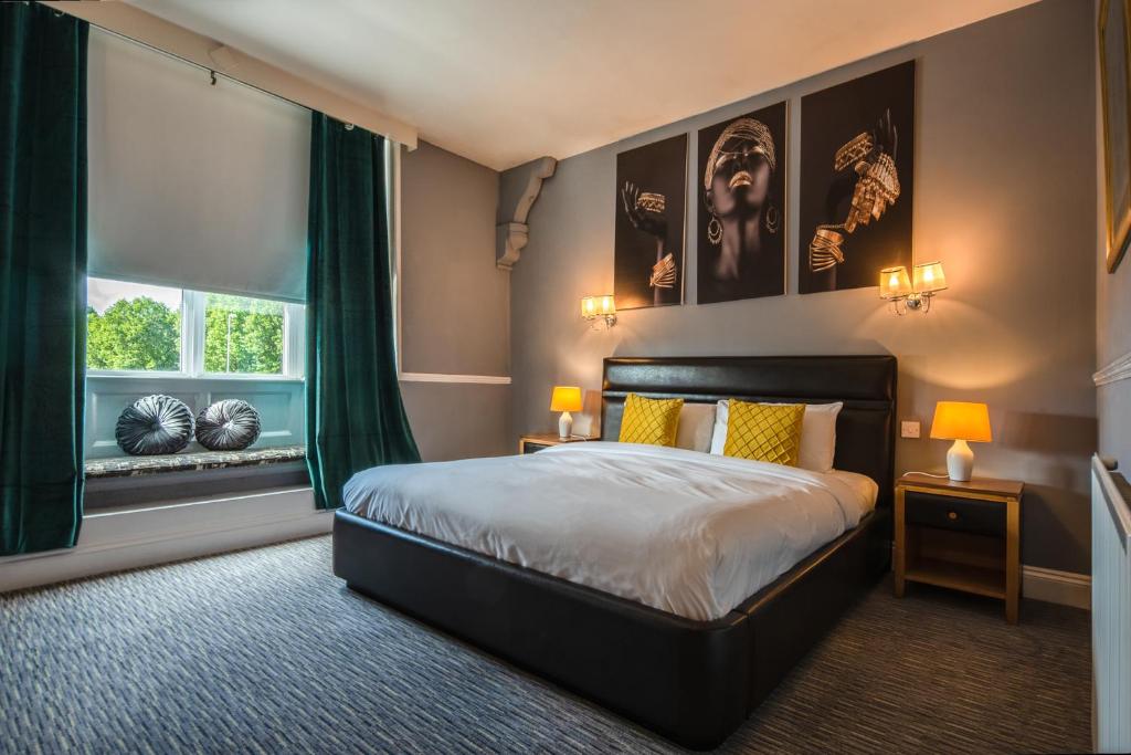 Un dormitorio con una cama grande y una ventana en Plough Hotel en Northampton