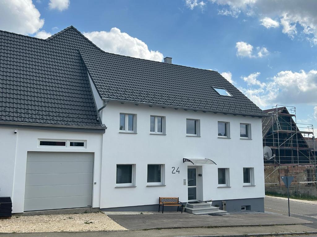 een wit huis met een garage bij Das Haus im Biosphärengebiet Schwäbische Alb in Dornstadt