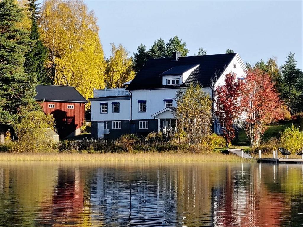a large house sitting next to a body of water at Sjöbo, Urlaub direkt am See in Rattsjöberget