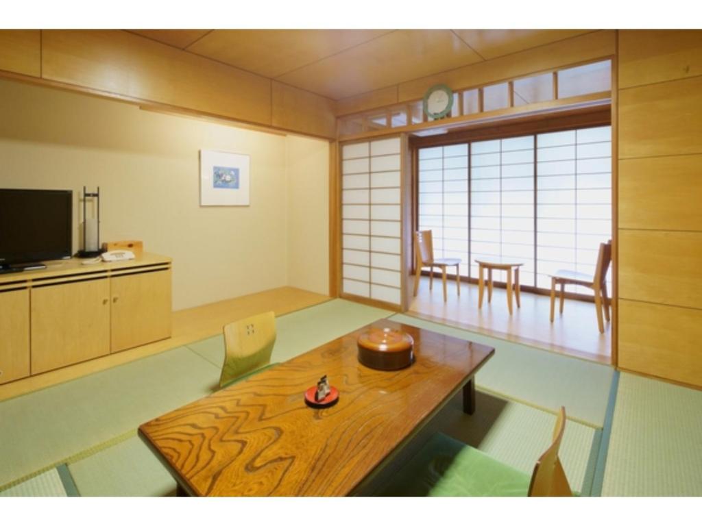 un salon avec une table en bois et une télévision dans l'établissement Misato no Yu Kajikaso - Vacation STAY 22197v, à Kimino