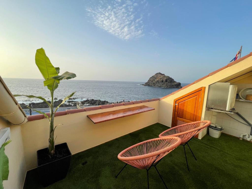 balcón con 2 sillas y vistas al océano en Vv La Joya Del Mar Suites, en Garachico