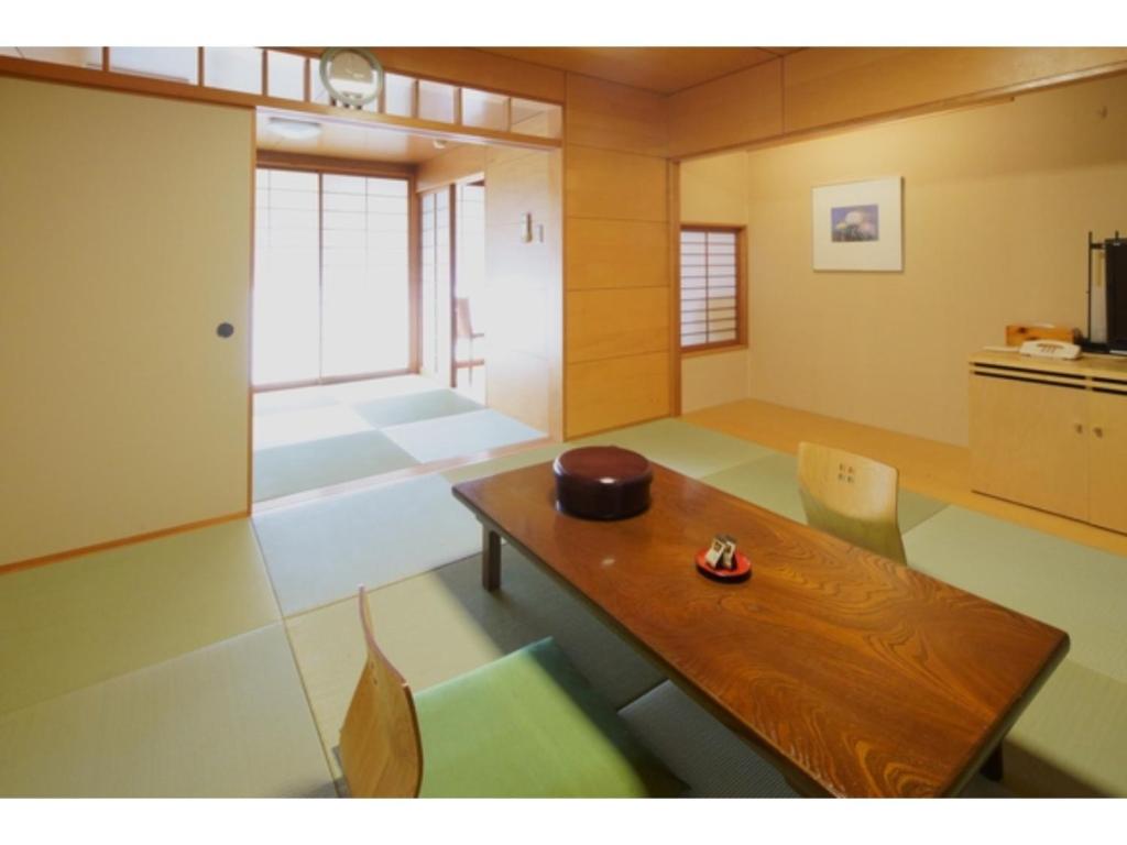 ein Wohnzimmer mit einem Holztisch und Stühlen in der Unterkunft Misato no Yu Kajikaso - Vacation STAY 22199v in Kimino