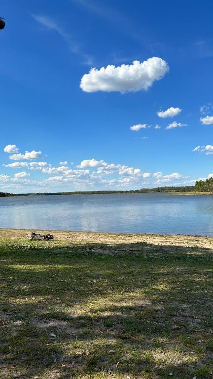 un gran cuerpo de agua con un cielo azul y nubes en Estancia Laserca, 