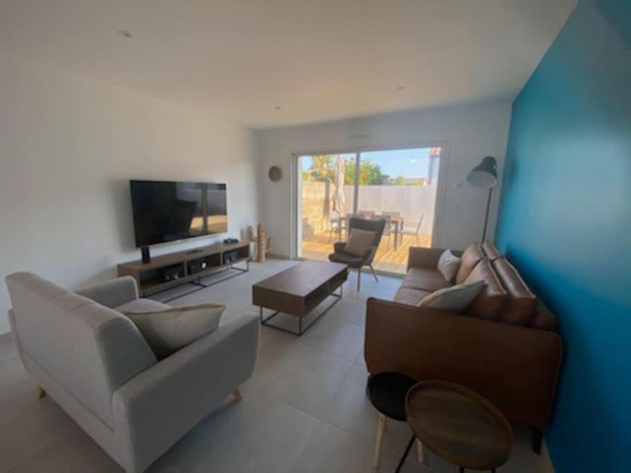 un salon avec des canapés et une télévision à écran plat dans l'établissement MAISON 3 chbres 3 étoiles St Gilles X de Vie, à Saint-Gilles-Croix-de-Vie