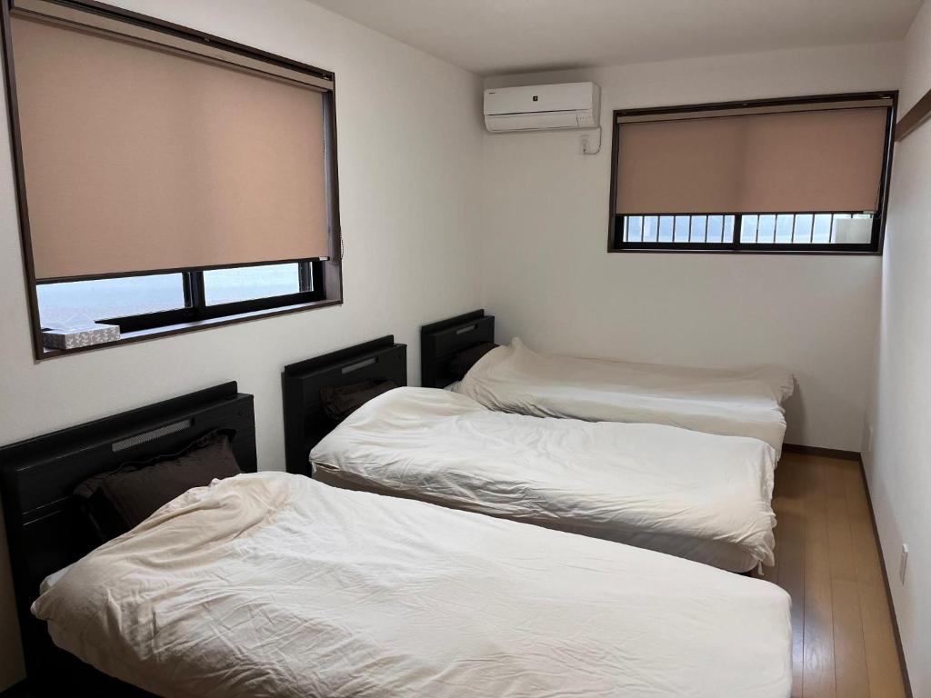 2 Einzelbetten in einem Zimmer mit 2 Fenstern in der Unterkunft Guesthouse Hatenashi - Vacation STAY 43934v in Hongu
