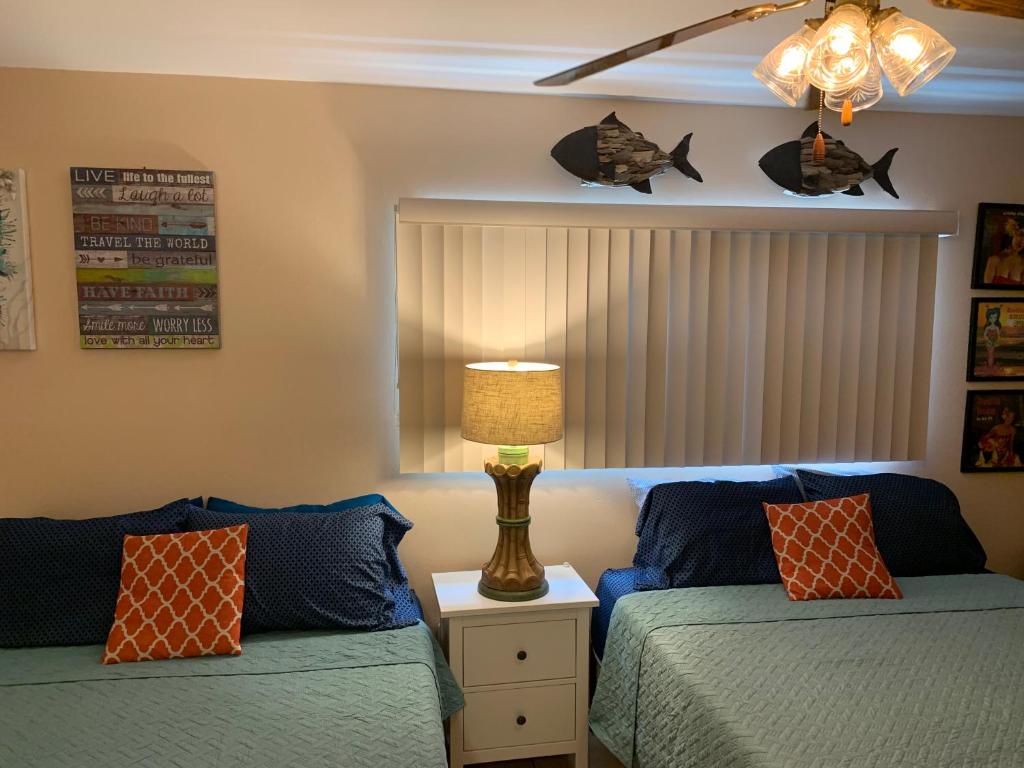 a bedroom with two beds and a lamp on a night stand at Michaels -Beachside Bungalows in St. Pete Beach