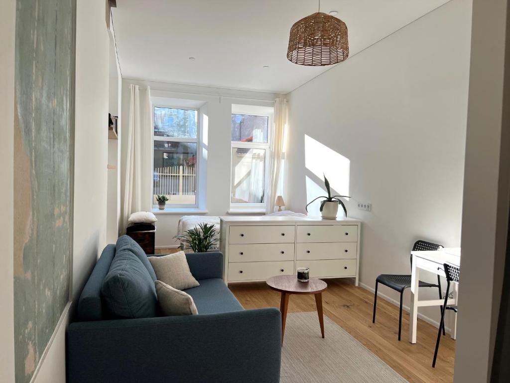 - un salon avec un canapé bleu et une table dans l'établissement Cozy studio in Sv Stepono g., à Vilnius