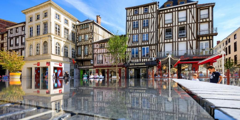 a city street with buildings in the rain at Bluepart 4 personnes in Chalons en Champagne