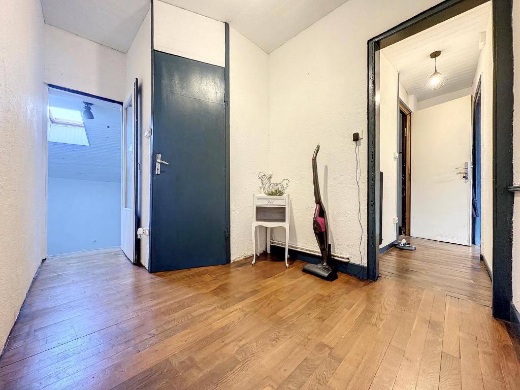 a hallway with a blue door and a wooden floor at Bluepart 4 personnes in Chalons en Champagne