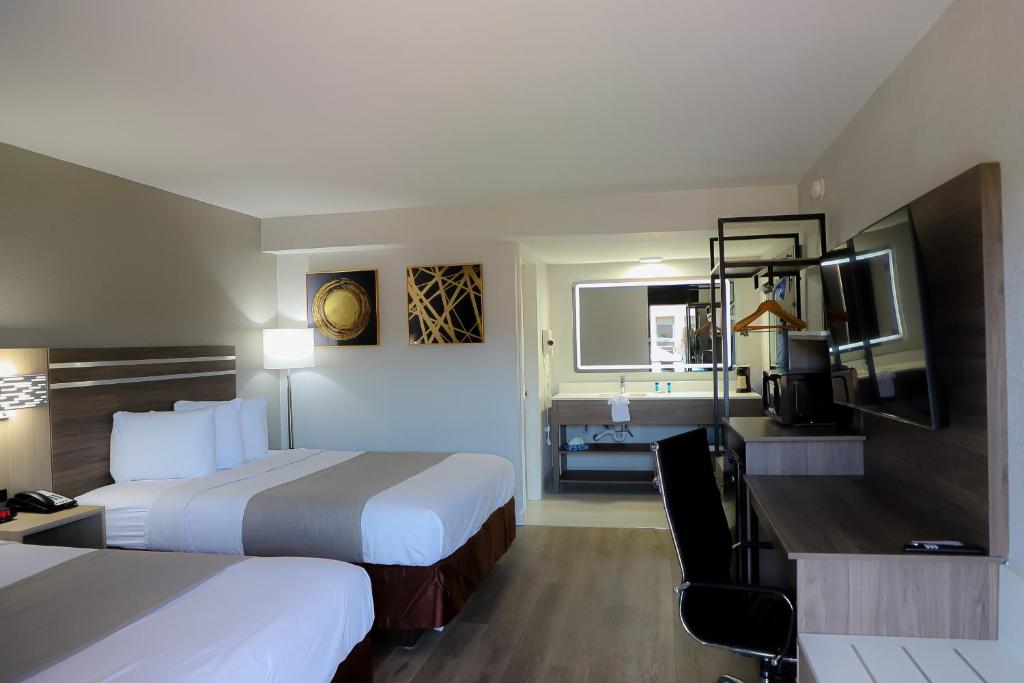 Habitación de hotel con 2 camas y escritorio en Airport Inn, en Nederland