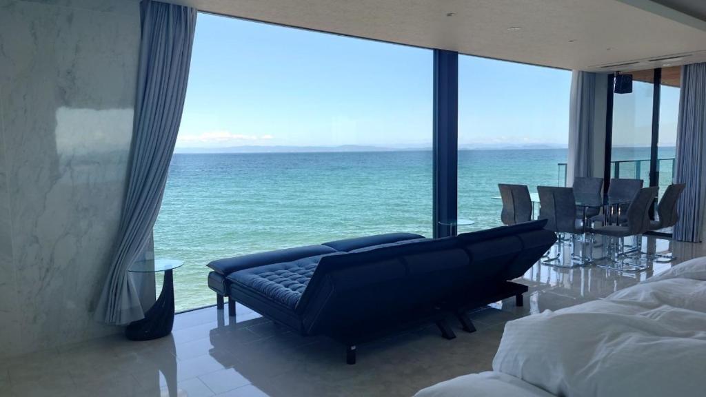uma sala de estar com um sofá e vista para o oceano em Namioto Terrace Suite Villa in AIGA - Vacation STAY 30551v em Sumoto