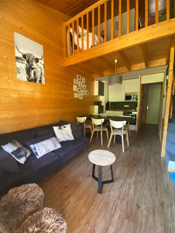 a living room with a couch and a table at Appartement duplex 6 couchages 2sdb Parking Ménage inclus in Valmorel