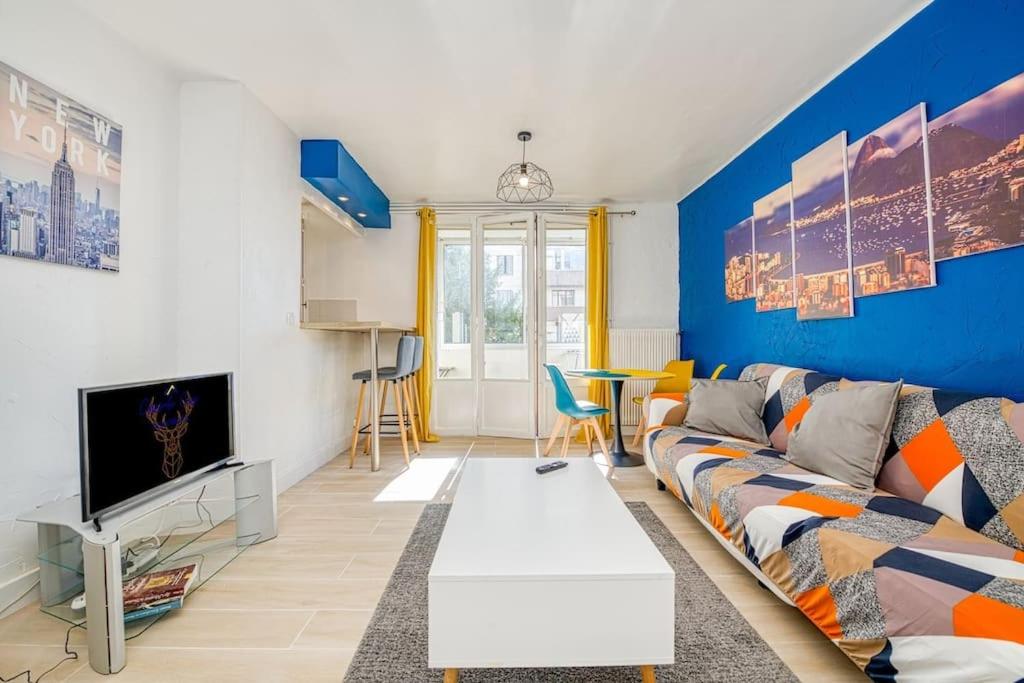 uma sala de estar com um sofá e uma televisão em Cocon chaleureux, 2 chambres, wifi avec fibre em Grenoble