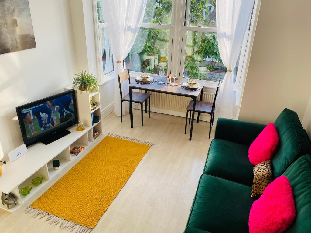 Willow’s Place في لايت أون سي: غرفة معيشة مع أريكة خضراء وطاولة