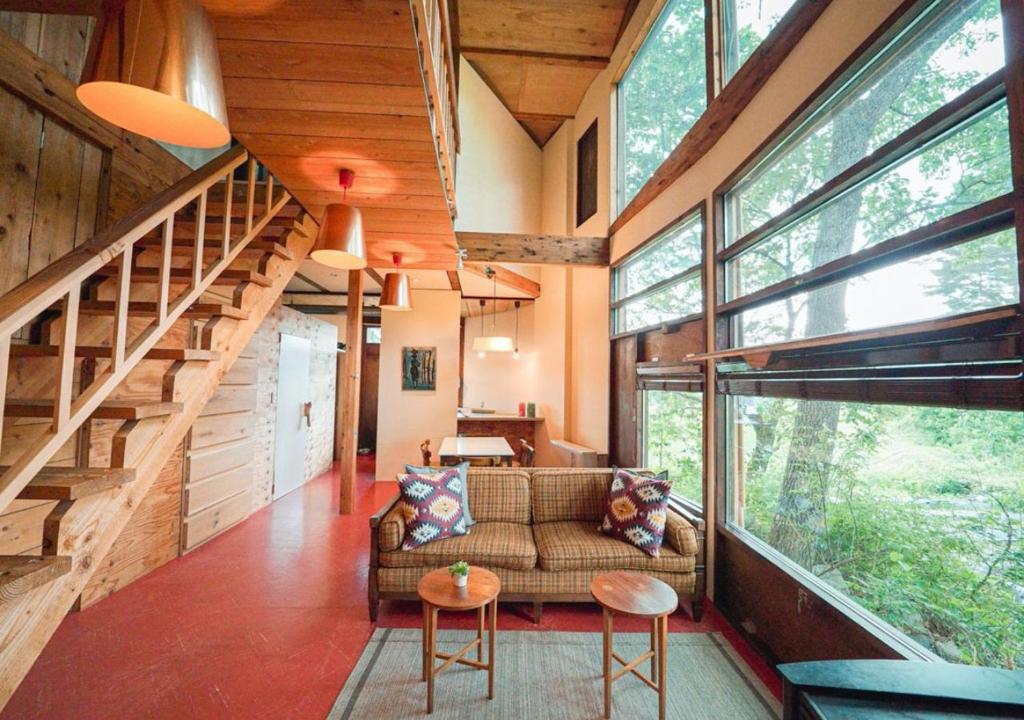 a living room with a couch and a staircase at OvalMountainLodge - Vacation STAY 34543v in Hakuba