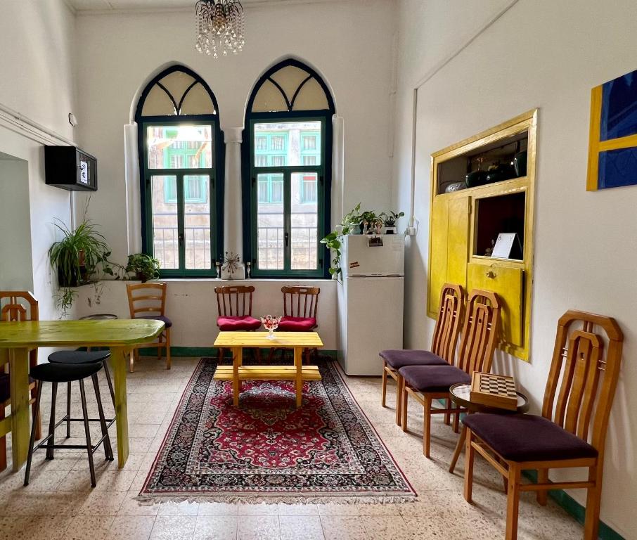 a living room with a table and chairs and a table and a tablektop at Shazly Inn in Nazareth