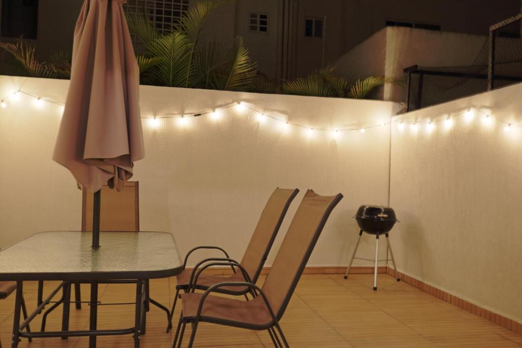 a table and chairs with an umbrella and lights at Casa familiar 3 habitaciones Playa del Carmen in Playa del Carmen