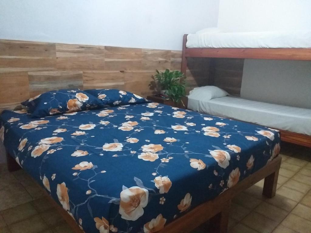 波薩達斯的住宿－Residencial Santiago Habitaciones Hotel bed & break fast，一张床上,床上有鲜花,有蓝色的毯子