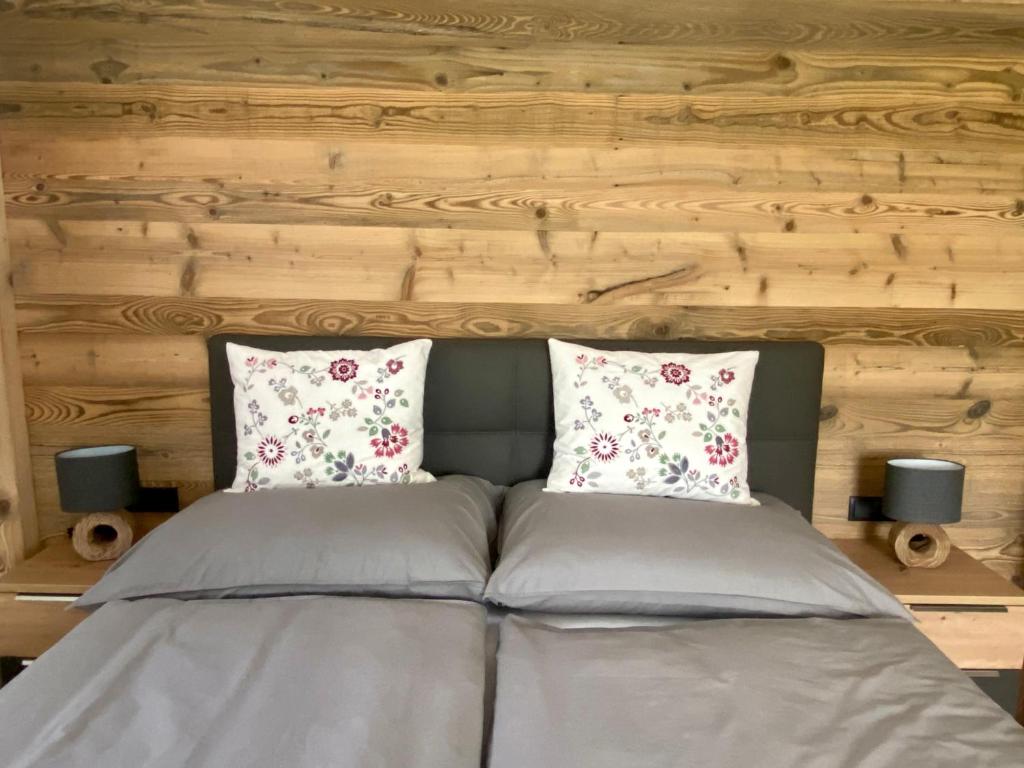 a bed with two pillows on top of it at APARTMENT DACHSTEIN - neu im Haus Wieseneck in Ramsau am Dachstein