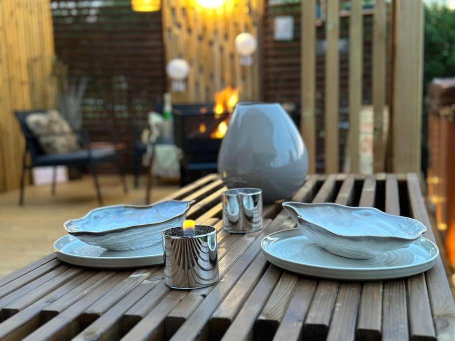 een houten tafel met twee borden en kaarsen erop bij «Sea View Apartment Finnøy Island» in Stavanger