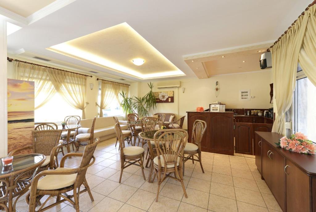 a dining room with tables and chairs and a kitchen at Amalia in Paleo Tsifliki