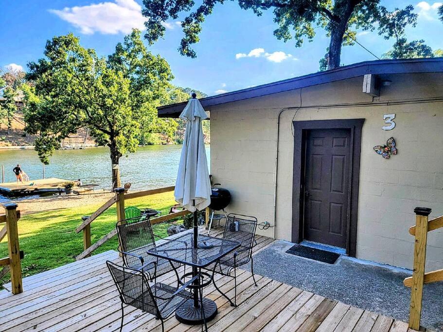 a patio with a table and an umbrella on a deck at #03 - Fantastic Lakeside Studio Cottage- Pet Friendly in Hot Springs